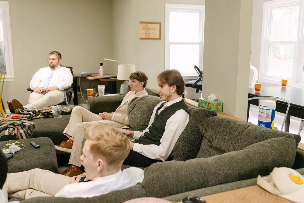 groomsmen relaxing on the couch before the forest wedding ceremony