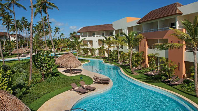 Vista exterior de las instalaciones del Dreams Royal Beach Punta Cana, mostrando su diseño acogedor, áreas ajardinadas y la cercanía a la playa en un entorno tropical.