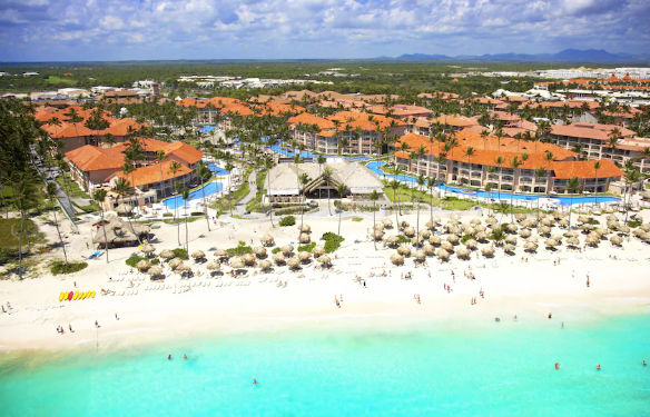 Vista de un resort en la zona de Bávaro, Punta Cana, destacando su arquitectura, áreas ajardinadas y la integración con el entorno costero tropical.