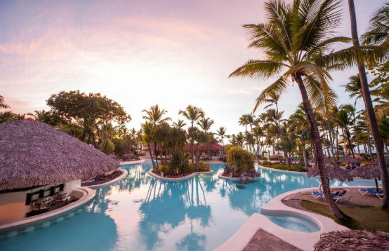 Vista de un resort en la zona de Bávaro, Punta Cana, destacando el diseño de las instalaciones y el entorno tropical que rodea al complejo hotelero.