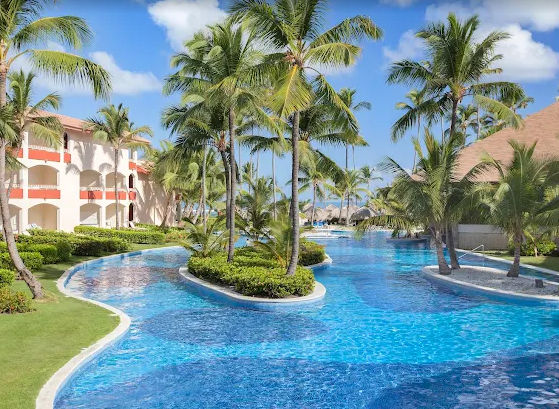 Vista del área de piscina de un hotel en Punta Cana con tumbonas y vegetación tropical