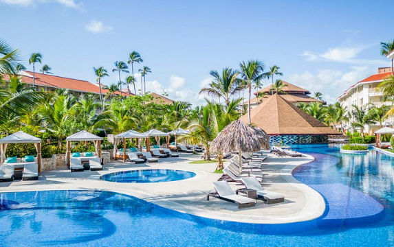 Vista de las instalaciones de lujo y arquitectura moderna del Majestic Mirage Punta Cana, destacando su entorno elegante y áreas de descanso rodeadas de vegetación tropical.