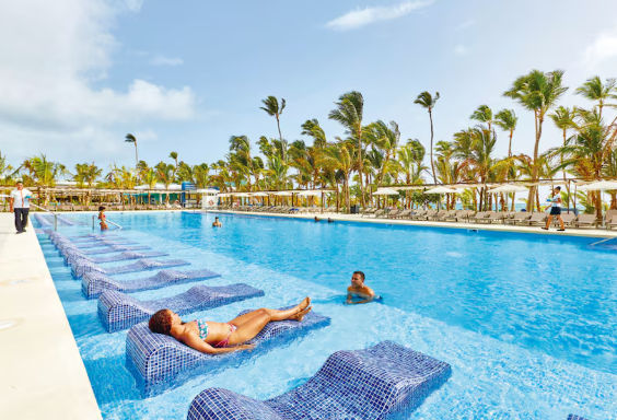 Vista de las instalaciones del resort Riu en Punta Cana, destacando su arquitectura, áreas recreativas y el entorno tropical que rodea al complejo.