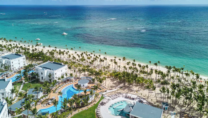Vista de las instalaciones del complejo hotelero Riu en Punta Cana, destacando su arquitectura, áreas de piscina y el entorno tropical que rodea al resort.