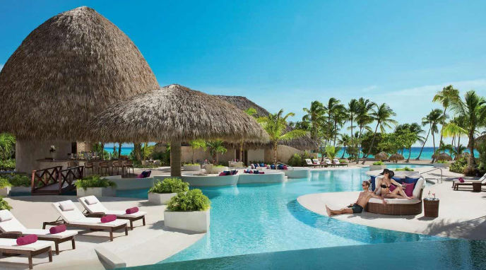 Vista de las instalaciones del Secrets Resort en Punta Cana, destacando su ambiente romántico, diseño elegante y áreas de descanso frente al mar Caribe.