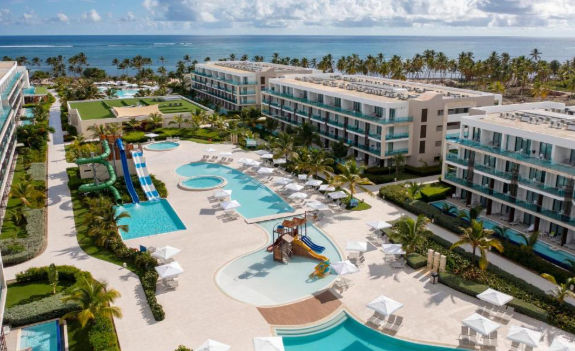Vista de las instalaciones y áreas exteriores del Serenade Punta Cana Beach & Spa Resort, destacando su diseño moderno, entorno tropical y acceso a la playa en el Caribe.