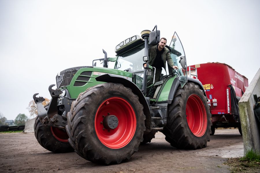 Landwirt schaut aus seinem Fendt Traktor mit Anhänger