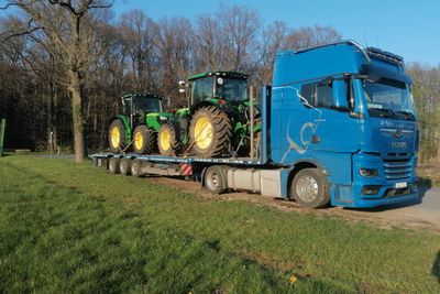 Zwei John Deere Traktoren verladen auf einem Truck zum Transport ins Ausland