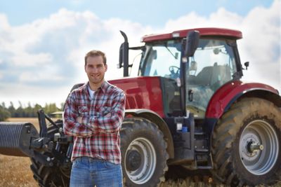 Farmer in front of his red tractor