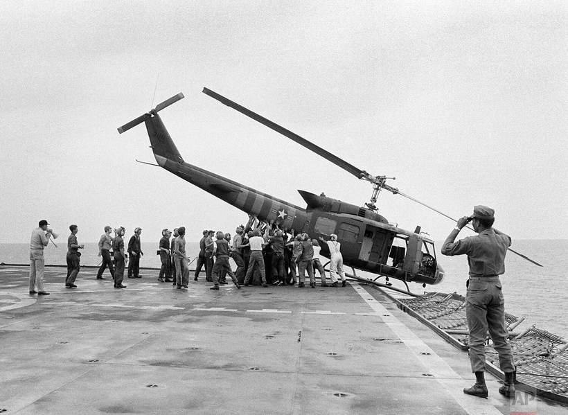 Sailors pushing a helicopter across a carrier deck during the 1975 evacuation.