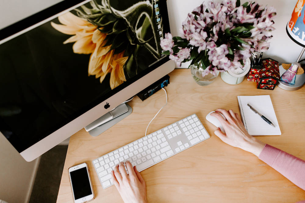 The Ellanyze office work space: iMac, flowers, light birch desk