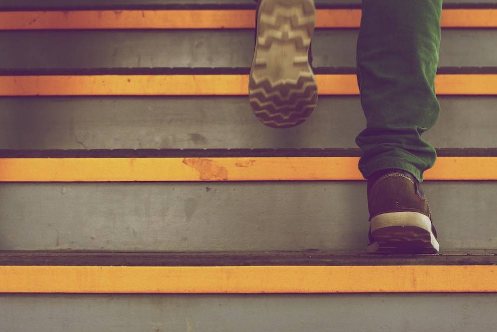 Marketing Overwhelm - marketing burnout tips man walking up the steps