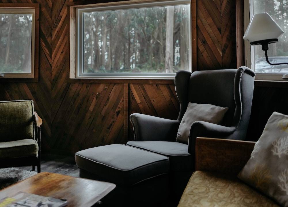 things to do on staycation - a cozy chair in a living room with wood panel walls