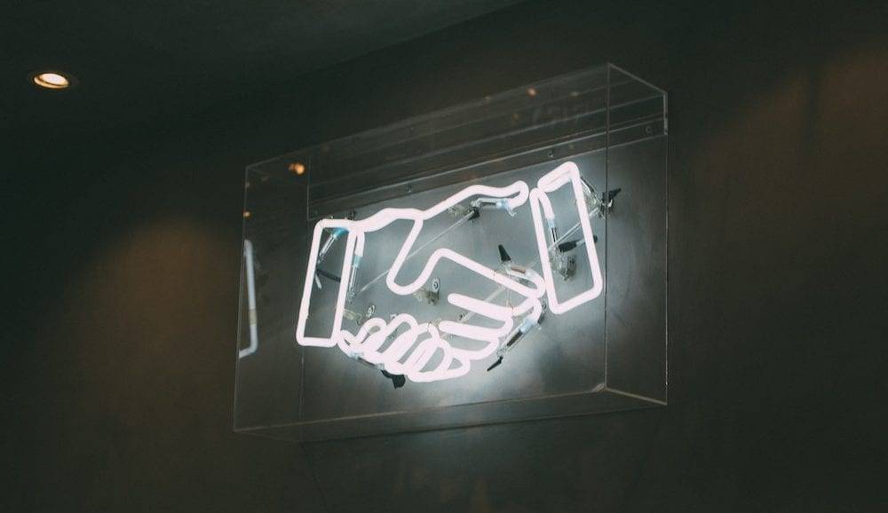 secrets to fantastic client - a lit sign of a handshake relationships