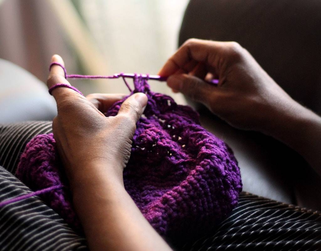 finding flow getting in the zone - woman knitting a purple scarf