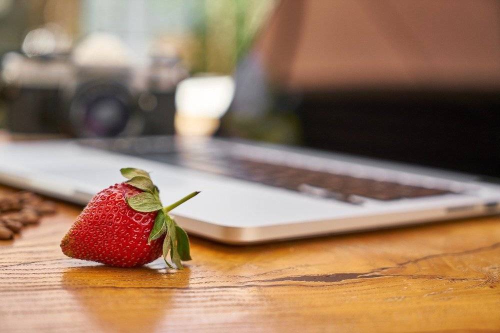 website tips: strawberry sitting in front of a laptop computer