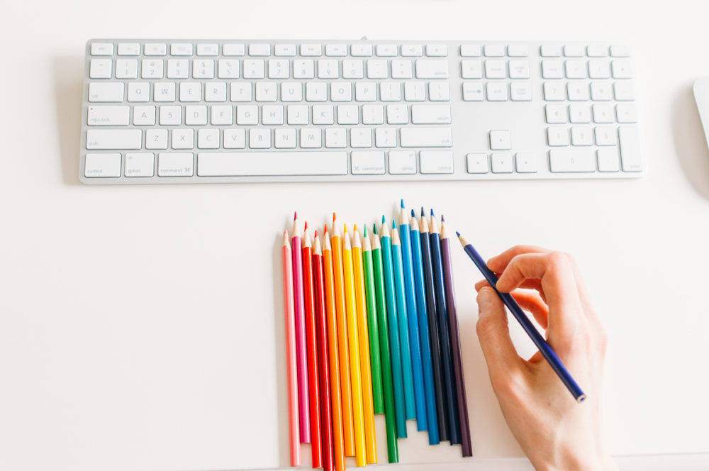 computer keyboard with rainbow colored pencils