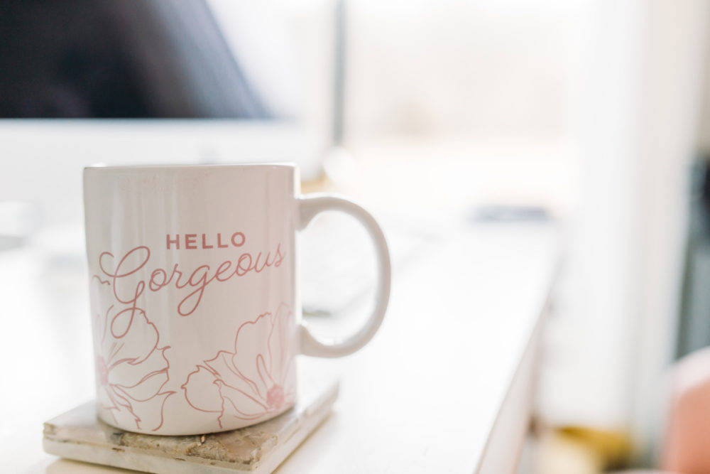 A mug sitting on the desk by the computer