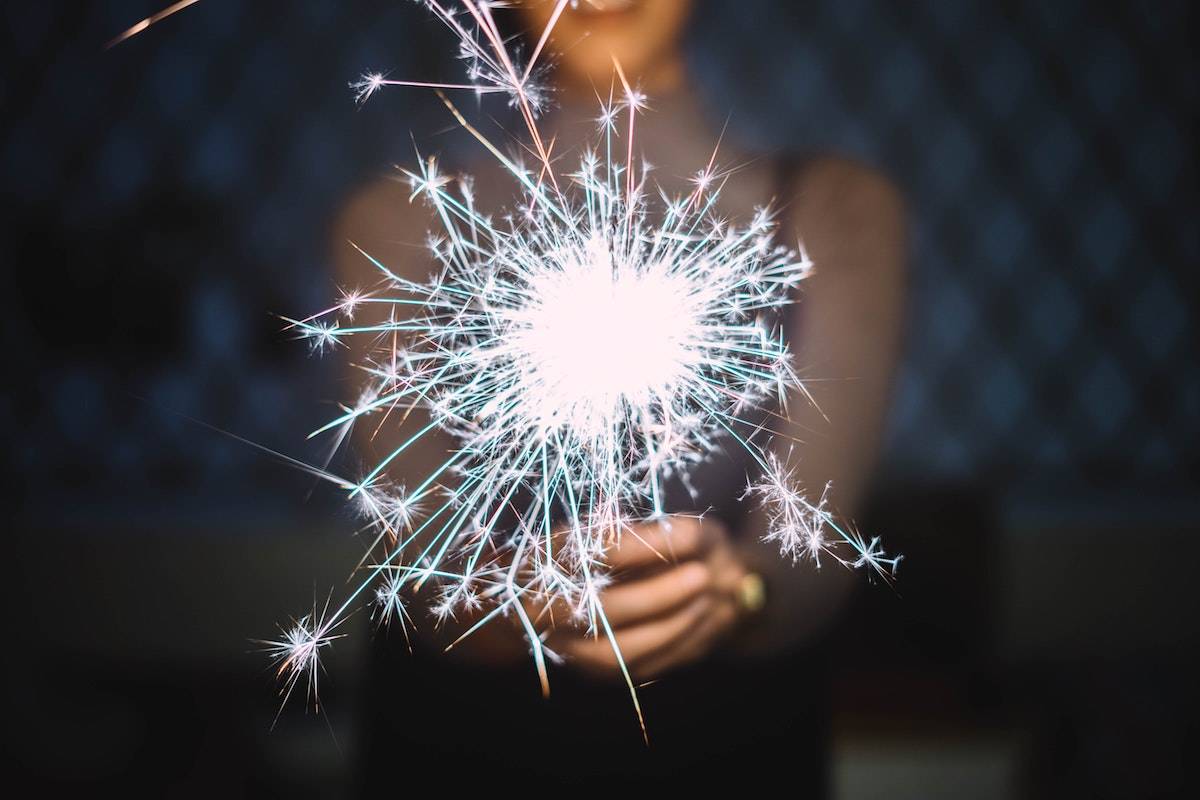 How to Become More Creative: a woman holding a bright sparkler