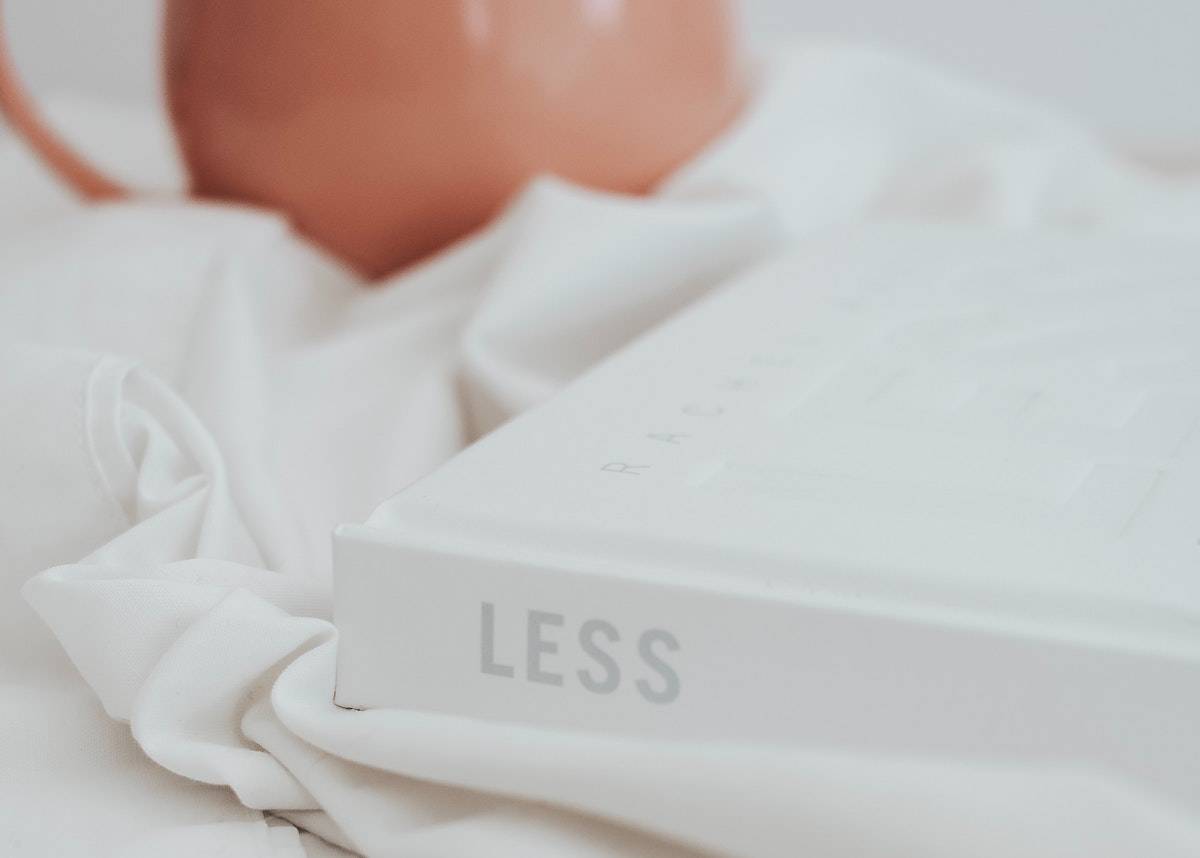 What Do You Need To Be Happy? a white book laying in the bed sheets with the word 