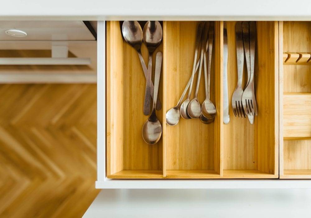 How to Feel Happy Again: silverware inside a wooden drawer in a white kitchen