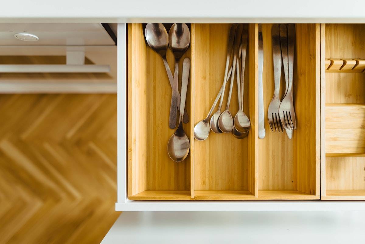 How to Feel Happy Again: silverware inside a wooden drawer in a white kitchen