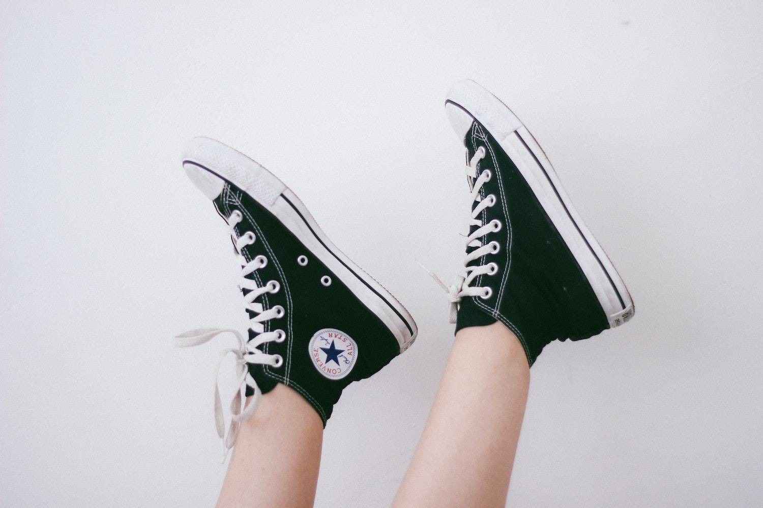 creative website ideas: two feet sticking up in the air, wearing black converse