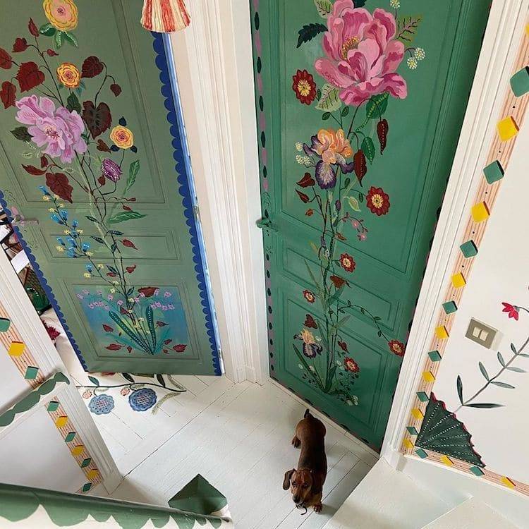 the inside of a house and stairwell with ornate and colorful flowers painted on the walls from floor to ceiling