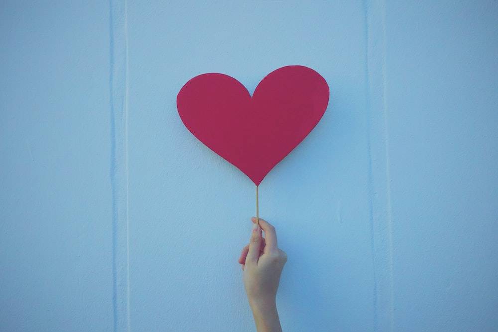 What pages should I have on my website? person holding up a red paper heart