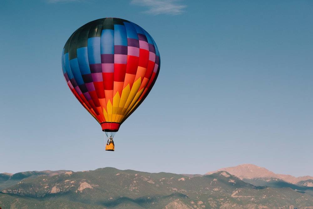 website color psychology - rainbow hot air balloon flying over the desert