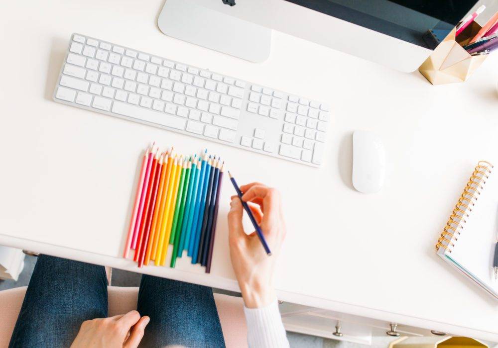 Janelle at her desk with colored pencils