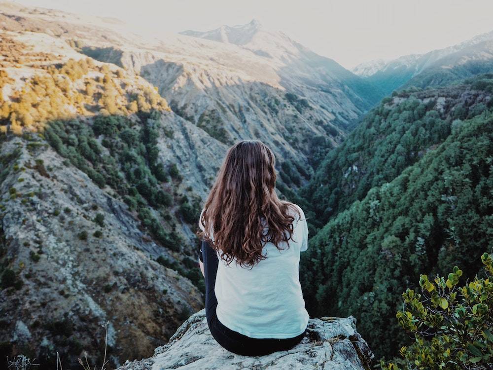 a woman thinking and looking at the mountains