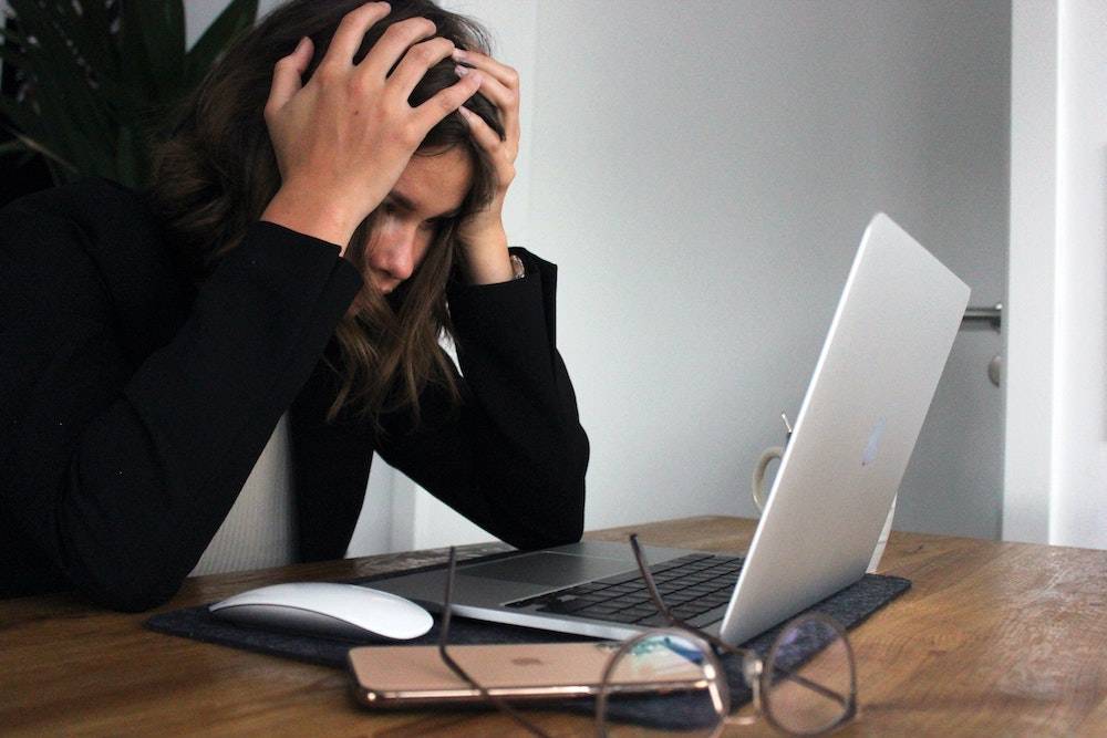 woman at laptop looking overwhelmed