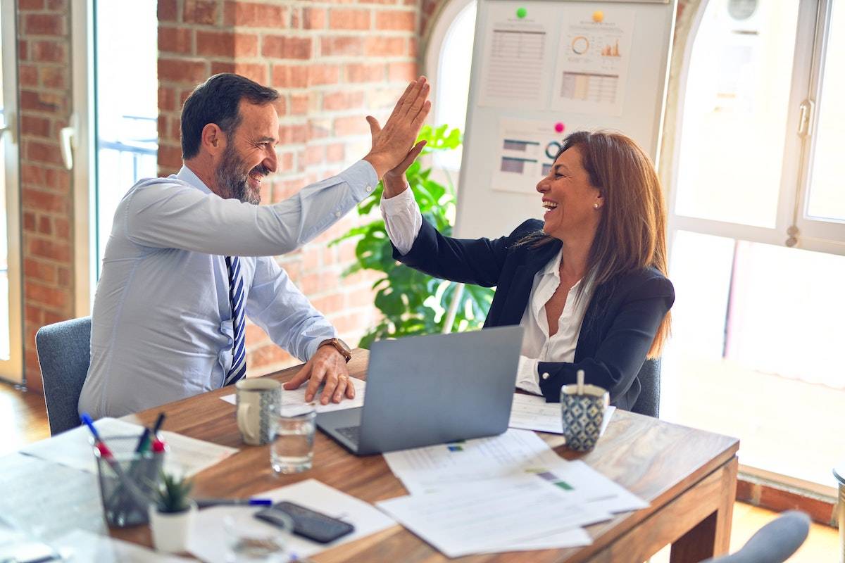 two people high-fiving in an office