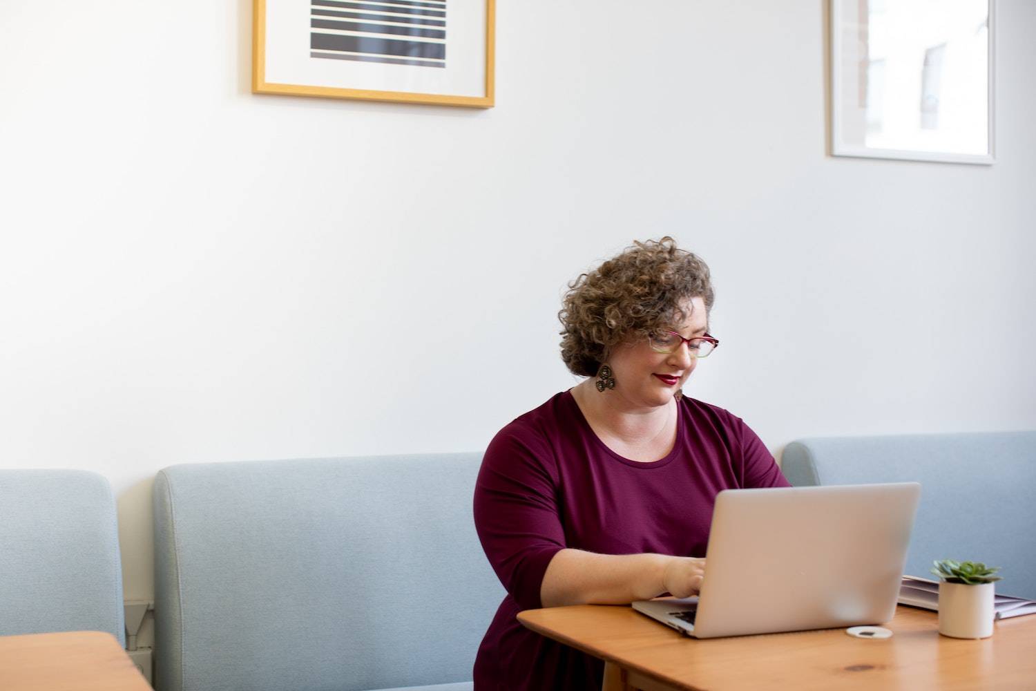 plus size woman working on her website SEO at her laptop smiling