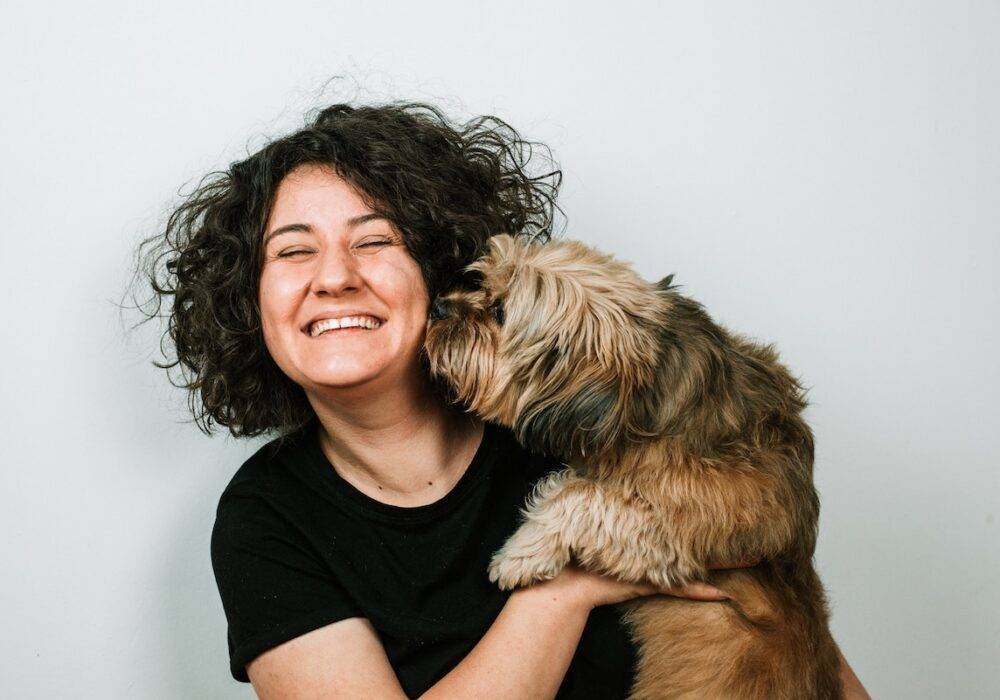 woman getting kisses from her dog