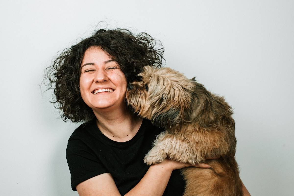 woman getting kisses from her dog