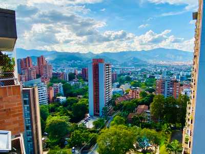 Medellin city skyline under blue sky with mountains in the background