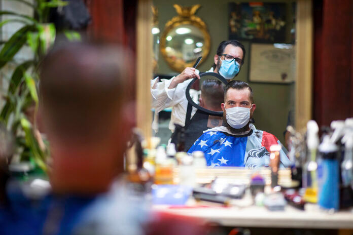 DOUBLE CHECKING: Barber Mike McAndrew holds a mirror as customer Rob Verrastro looks at his new haircut at Three Saints Barbershop and Shave Parlor in Jessup, Pa. Small businesses such as this are desperately trying to stay afloat during the coronavirus crisis, but billions of dollars allocated for aid by Congress may be left on the table. / TIMES-TRIBUNE VIA AP FILE/CHRISTOPHER DOLAN