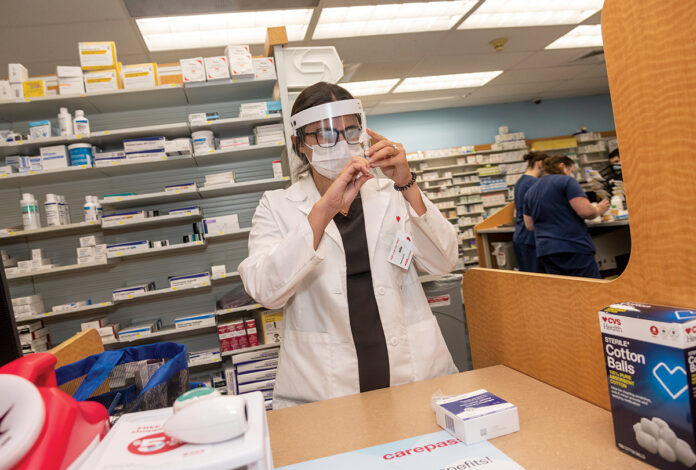 AT THE READY: Julia Tiberi, CVS pharmacy manager in Cumberland, prepares a dose of the flu vaccine. / PBN PHOTO/MICHAEL SALERNO AT THE READY: Julia Tiberi, CVS pharmacy manager in Cumberland, prepares a dose of the flu vaccine. / PBN PHOTO/MICHAEL SALERNO