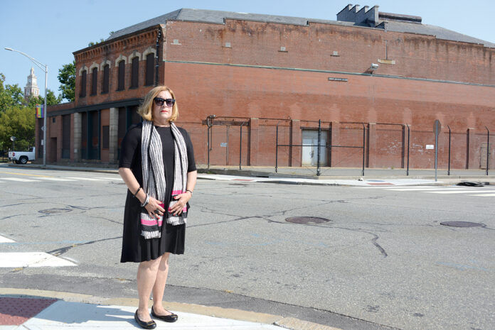 PARK CONCERNS: Sharon Steele, president of the Jewelry District Association, stands in front of the proposed site for the Dyer Street bus hub. She’s an opponent of the Providence Multi-Hub Bus System, in part because she believes that people waiting for buses at the Dyer Street hub would spill into the nearby waterfront park, diminishing the park’s intended use. / PBN PHOTO/ELIZABETH GRAHAM PARK CONCERNS: Sharon Steele, president of the Jewelry District Association, stands in front of the proposed site for the Dyer Street bus hub. She’s an opponent of the Providence Multi-Hub Bus System, in part because she believes that people waiting for buses at the Dyer Street hub would spill into the nearby waterfront park, diminishing the park’s intended use. / PBN PHOTO/ELIZABETH GRAHAM