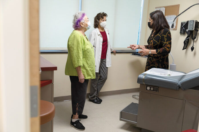 ESSENTIAL SERVICE: The Rhode Island Free Clinic has provided more than 40,000 free patient visits to uninsured, low-income adults over the last five years. CEO Marie Ghazal, right, speaks with primary care provider Marina Rodriguez, center, and psychiatric clinical nurse specialist Sylvia Weber. / PBN PHOTO/RUPERT WHITELEY ESSENTIAL SERVICE: The Rhode Island Free Clinic has provided more than 40,000 free patient visits to uninsured, low-income adults over the last five years. CEO Marie Ghazal, right, speaks with primary care provider Marina Rodriguez, center, and psychiatric clinical nurse specialist Sylvia Weber. / PBN PHOTO/RUPERT WHITELEY