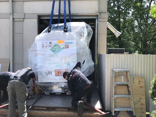 WORKERS MOVE a new 7.23-ton MRI machine into Rhode Island Medical Imaging Inc.’s Warwick building. / COURTESY RHODE ISLAND MEDICAL IMAGING INC.