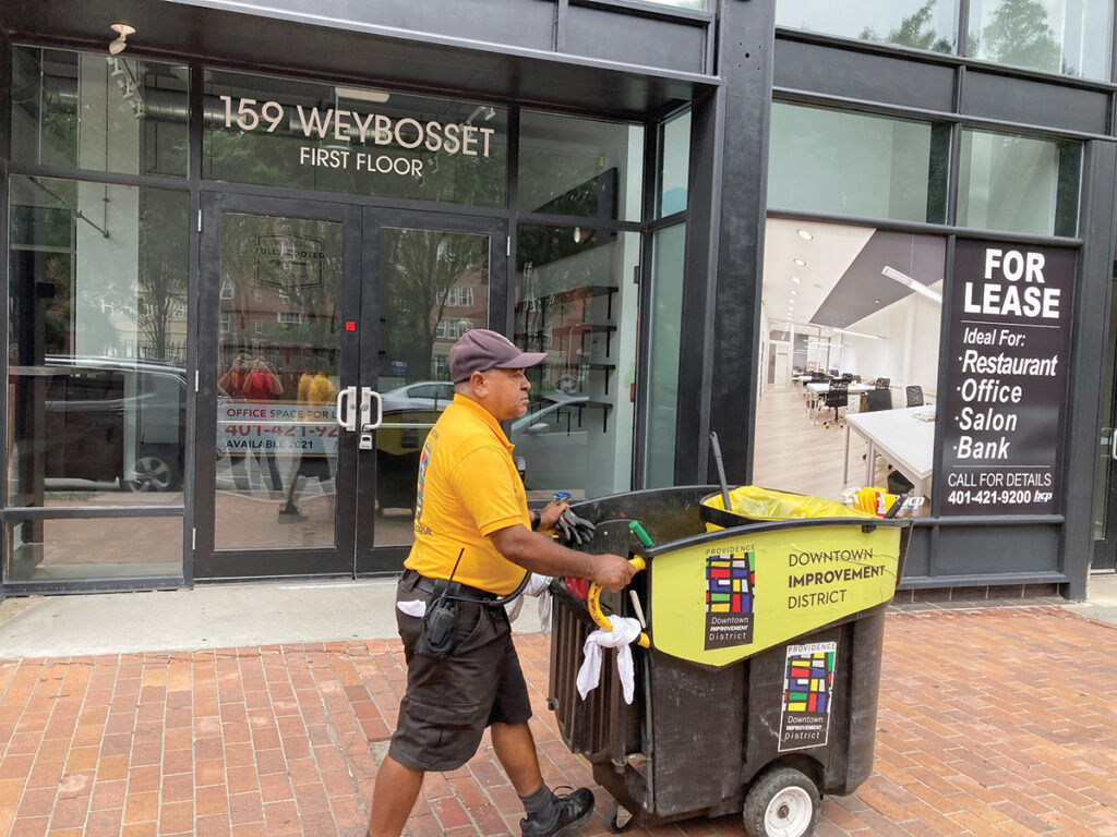 KEEPING IT CLEAN: A Downtown Improvement District ambassador walks past empty storefronts on Weybosset Street in Providence recently. / PBN FILE PHOTO/MARC LAROCQUE
