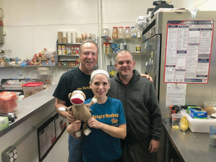 LOYAL STAFF: Tom Quinn, left, proprietor of The Hungry Monkey in Newport, says he’s grateful for his loyal staff who continued to come in to work throughout the COVID-19 pandemic. Standing with Quinn are wait staff member Leigh Ann Ford, who is holding “Socks The Hungry Monkey,” and chef Shawn Powers. / COURTESY THE HUNGRY MONKEY