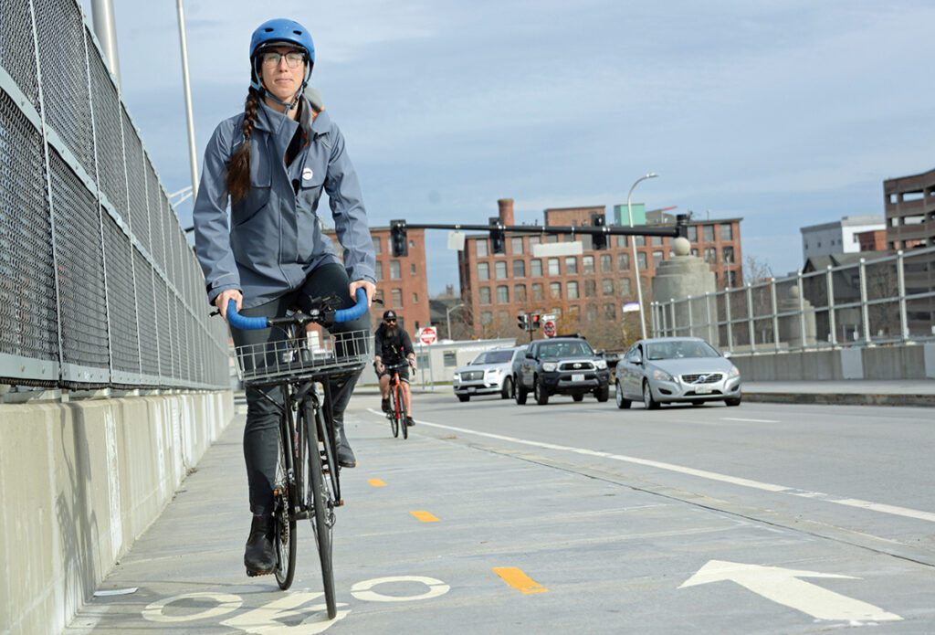 SELF-POWERED:  Liza Burkin, organizer for the Providence Streets Coalition, makes use of new bike lanes on the Clifford Street bridge over Interstate 95. Burkin has been a leading advocate for the city’s bike infrastructure. PBN PHOTO/ ELIZABETH GRAHAM