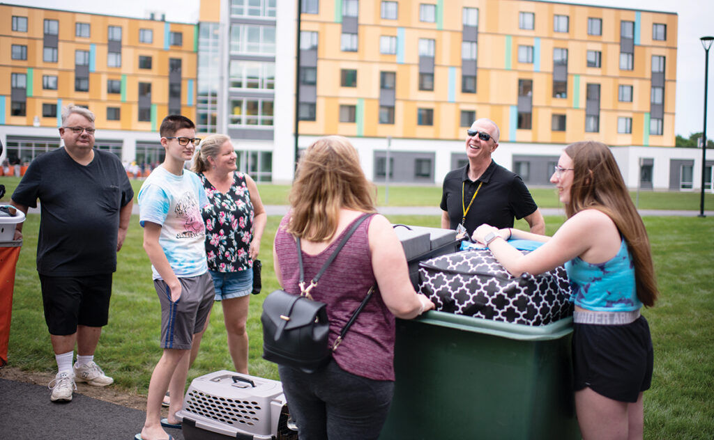 THE GREETER: Chancellor Mark Fuller, second from the right, chats with the family of a first-year student as they move items into a dorm on the University of Massachusetts Dartmouth campus in September 2021. / COURTESY UNIVERSITY OF MASSACHUSETTS DARTMOUTH