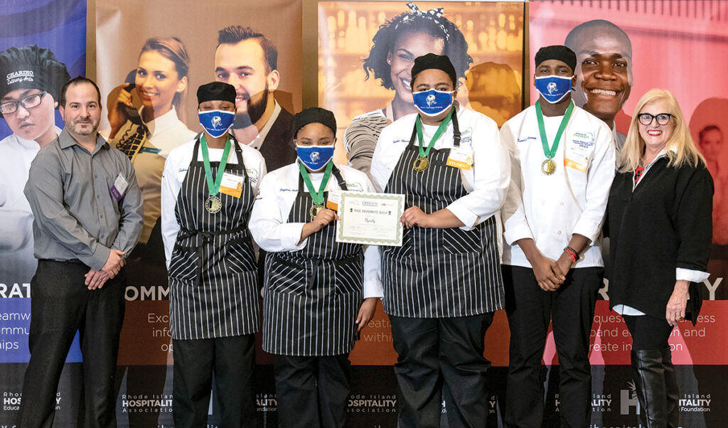 THE WINNERS: Steve Trabucco, left, director of kitchen operations at Gregg’s Restaurants and Taverns, and Dale J. Venturini, right, CEO and president of the Rhode Island Hospitality Association, pose with the winners of the Rhode Island ProStart High School culinary arts competition. From left are Exeter Job Corps Academy students Sabina Ulysse, Jacquline Ambler, Isabel Uzosike and Kiant’e Warren. / COURTESY GREGG’S RESTAURANTS AND TAVERNS