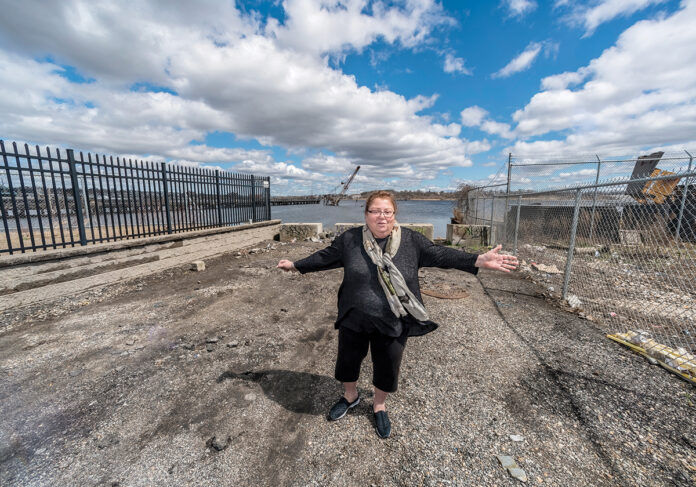 OPEN PATH: Linda Perri, a longtime resident of the Washington Park neighborhood in Providence, stands at a narrow public access point on the Providence working waterfront that she and other residents fought to establish. / PBN PHOTO/MICHAEL SALERNO