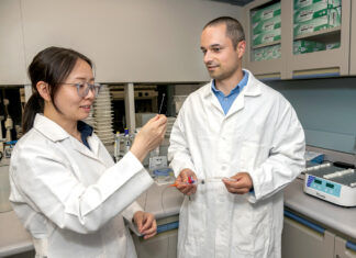 LAB TALK: Jennie Liu, left, research scientist, and Jason LaPorte, senior research associate for TriSalus Life Sciences, discuss the TriNav infusion system that will be tested to deliver treatments for pancreatic and liver tumors as part of a partnership with Lifespan Corp. / PBN PHOTO/MICHAEL SALERNO